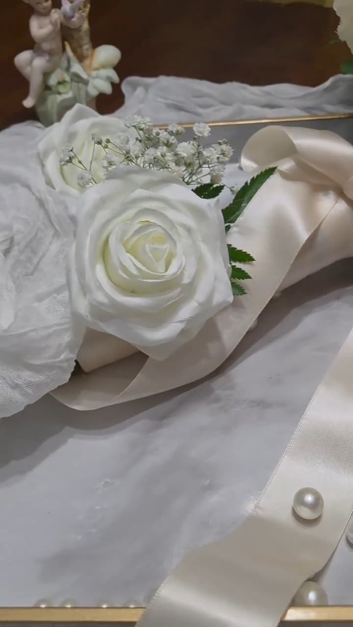 Single ivory rose corsage on satin ribbon surrounded by pearls