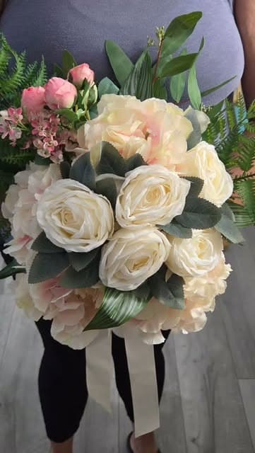 Round bridal bouquet of cream garden roses, blush spray roses and sage foliage finished with a long ivory ribbon